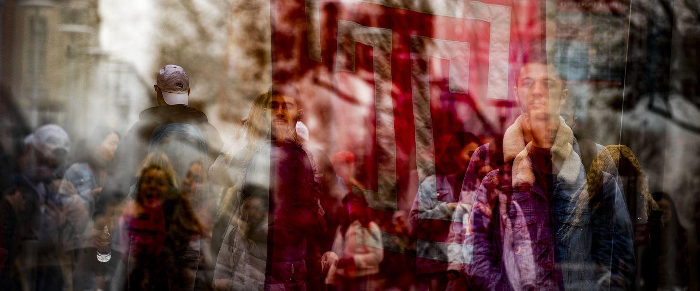 An abstract photo of the cherry Temple T flag overlay with students in the background